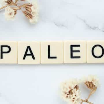 Image showing "PALEO" spelled out with letter tiles on a light surface, surrounded by dried flowers for a minimalist, natural look