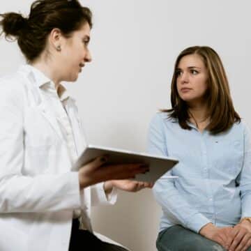 Doctor discussing thyroid health with a patient in a clinical setting, focusing on personalized care and diagnosis